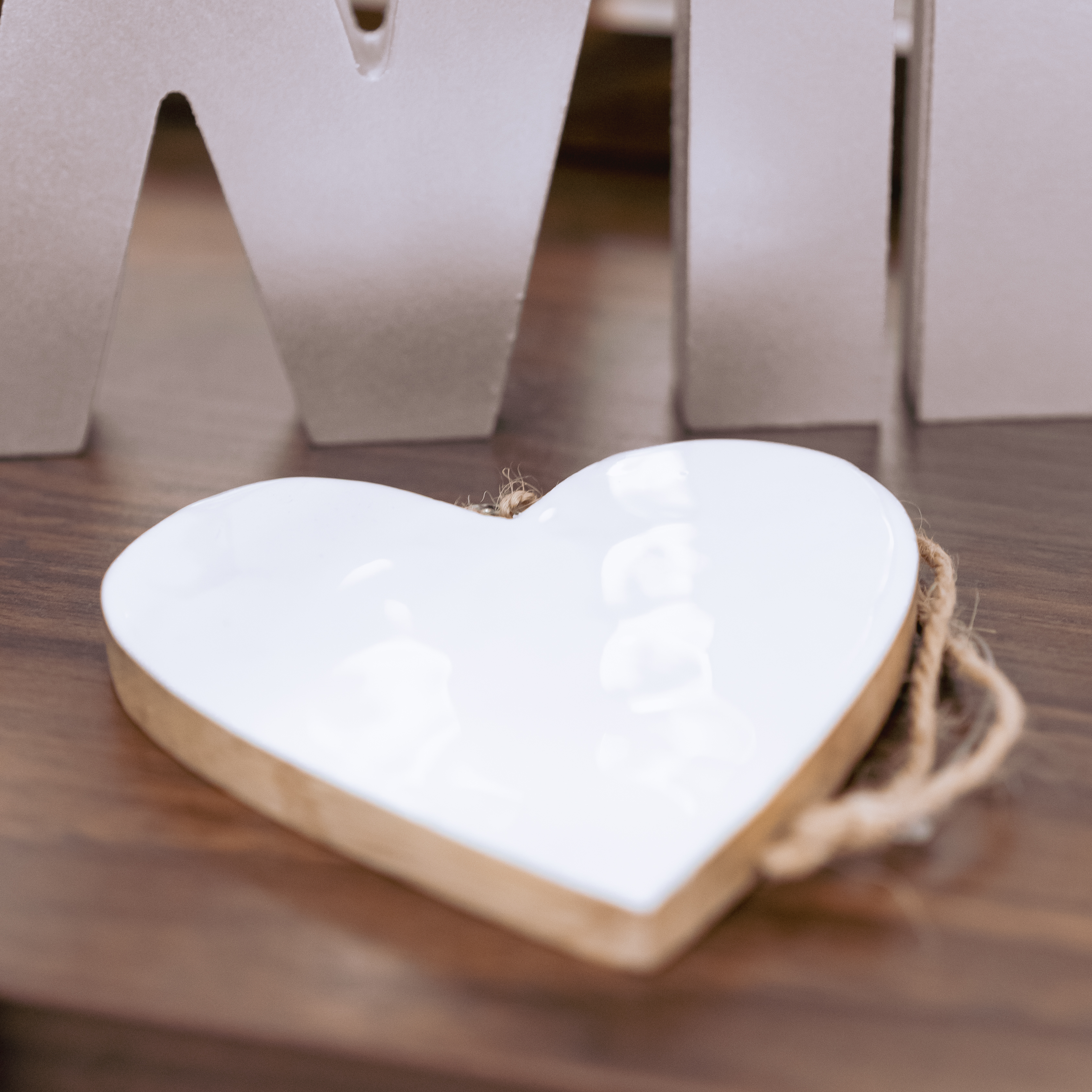 weißes Herz aus Mangoholz auf einem Holztisch gelegt