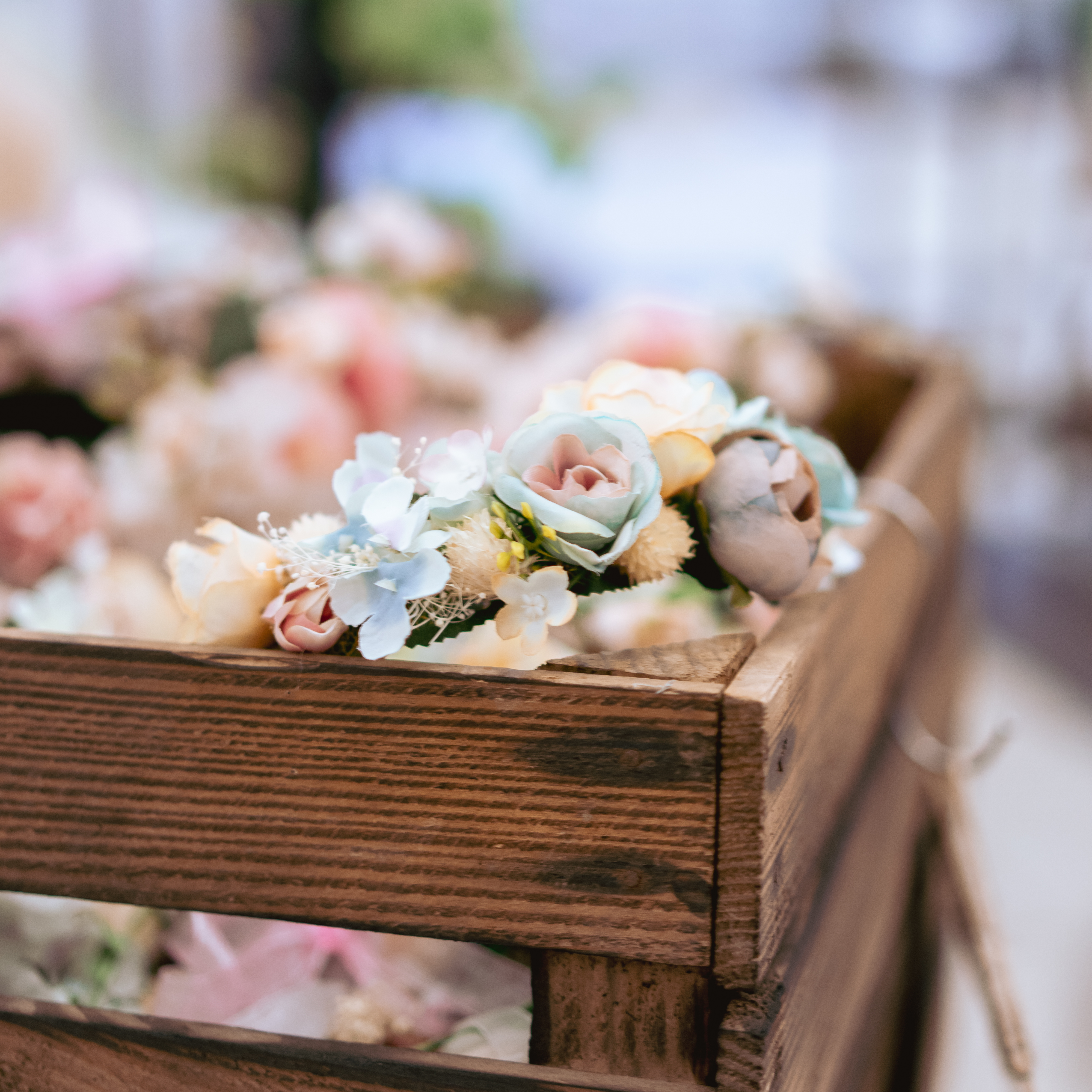 Blumenkranz bunt dekoriert in einer Holzkiste